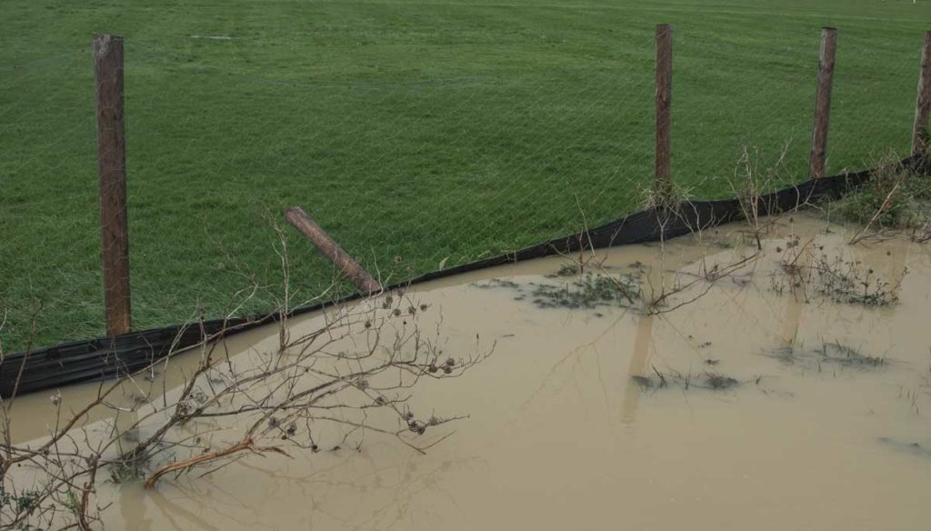 A failing silt fence holding back cubic meters of muddy water